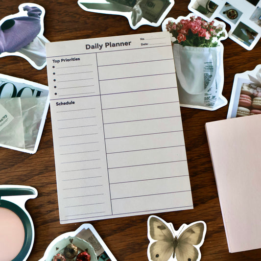 Daily planner on a wooden surface with various stickers around
