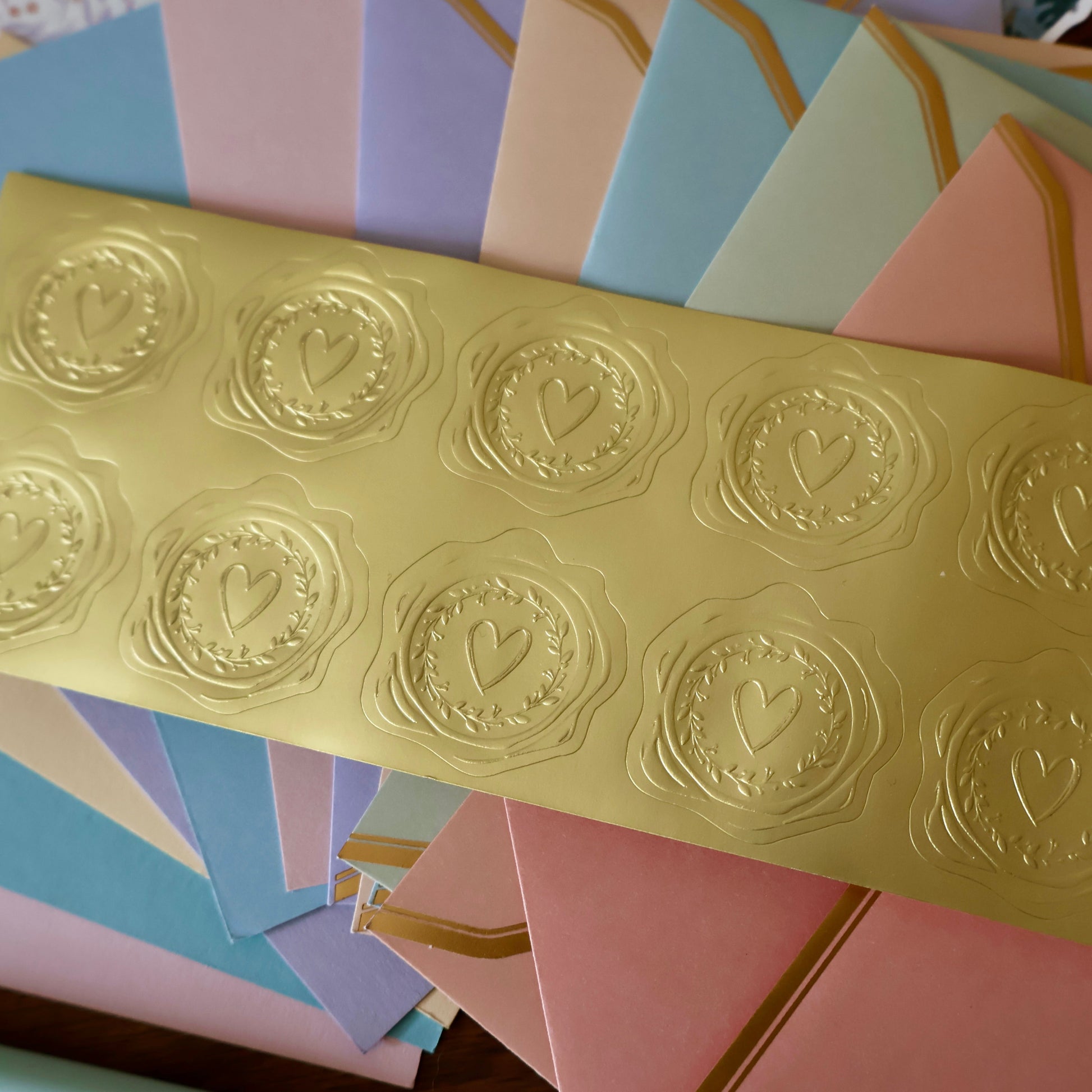 Gold embossed heart seal stickers on a colorful background