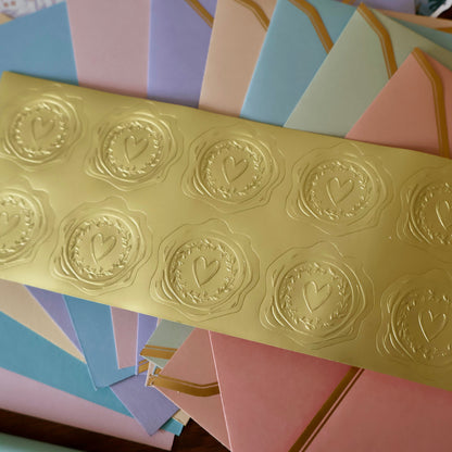 Gold embossed heart seal stickers on a colorful background