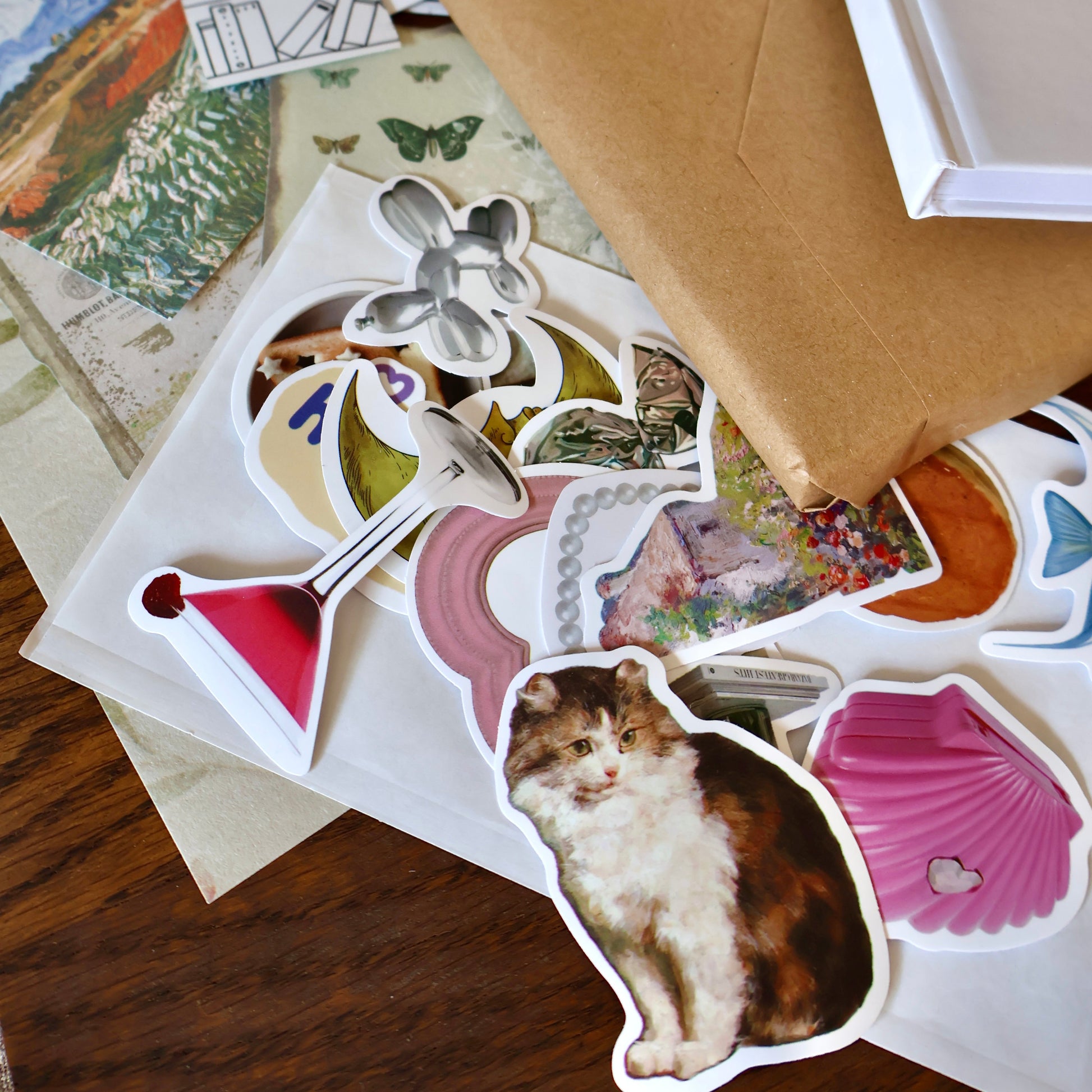 Collection of stickers on a surface with a brown journal and other stationery items.