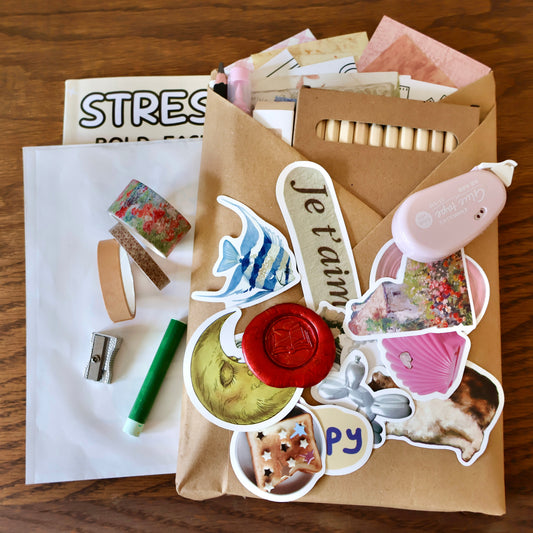 Kraft-wrapped journal with stickers and tapes sitting on top. Other stationery items stuffed in the kraft wrapping.